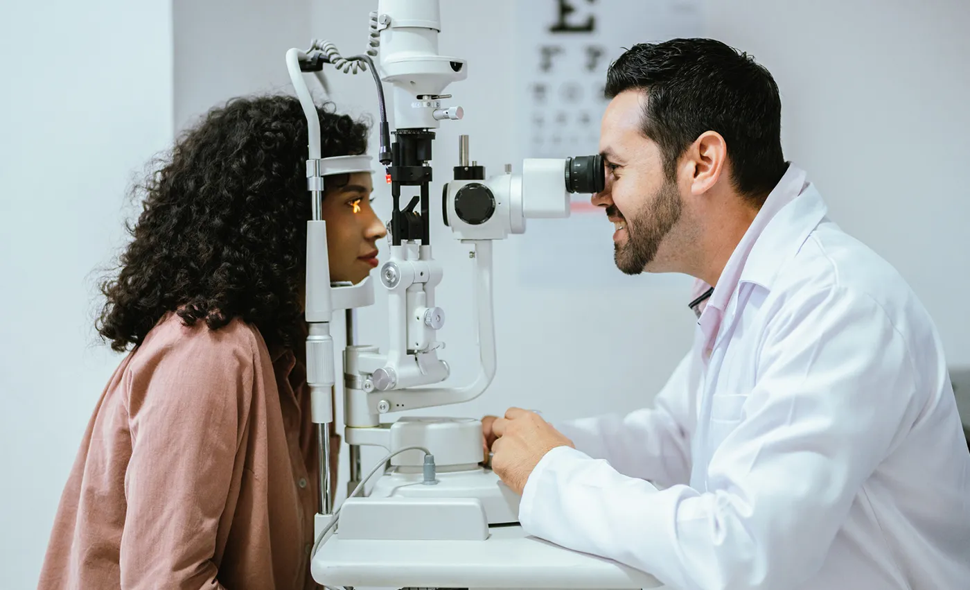 Ophthalmologist checking a patients eyes using a tool.