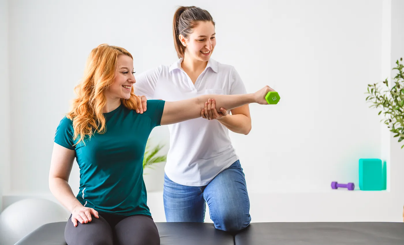 Physical therapy extending patients arms with weight.